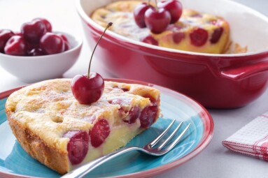 A piece of clafoutis with cherry on a plate. Traditional french cherry pie.