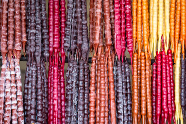 Multicolored delicious fresh Georgian Sweets Churchkhela hanging in the market