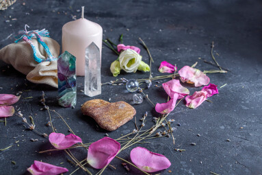 Magic,Composition,With,Pink,Candle,,Crystals,,Pagan,Bag,And,Flowers.