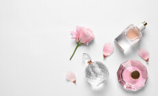 Different,Perfume,Bottles,And,Flowers,On,White,Background,,Top,View