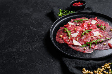 Marbled,Beef,Carpaccio,With,Arugula,And,Parmesan,Cheese.,Black,Background.