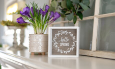 Hello,Spring,Sign,With,Purple,Flowers,On,The,Mantel