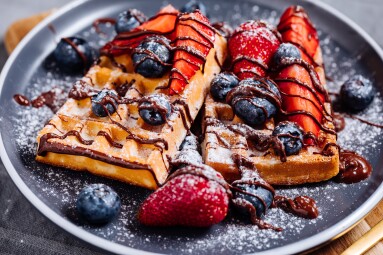 Belgian,Waffle,With,Chocolate,,Strawberry,,Blueberries,And,Powdered,Sugar,On