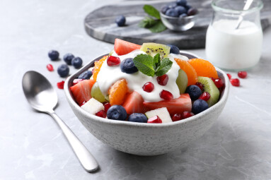 Delicious,Fruit,Salad,With,Yogurt,On,Grey,Table