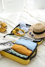 Open,Suitcase,Full,Of,Clothes,,Shoes,And,Summer,Accessories,On