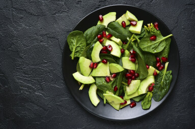Avocado,Salad,With,Baby,Spinach,And,Pomegranate,On,A,Black
