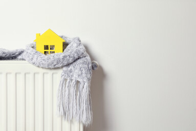 House,Model,Wrapped,In,Scarf,On,Radiator,Indoors,,Space,For