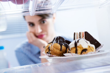 Young,Hungry,Woman,In,Front,Of,Refrigerator,Craving,Chocolate,Pastries.
