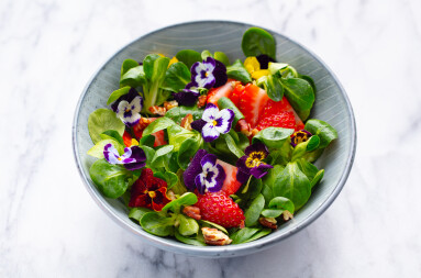 Fresh,Green,Salad,With,Strawberries,And,Edible,Flowers,In,A