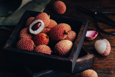 Small,Box,Of,Fresh,Lychees,On,Wooden,Table