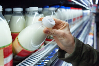 Womans,Hand,Holding,Milk,Bottle,In,Supermarket.,Man,Shopping,Milk