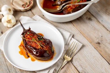 Stuffed,Roasted,Aubergine,With,Tomato,Sauce,Served,On,A,Plate,