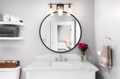 A,Bathroom,Detail,With,A,White,Cabinet,,Black,Circular,Mirror,