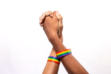 Two,Asian,Man,Holding,Hands,With,A,Rainbow-patterned,Wristband,On