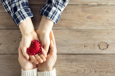 Red,Heart,In,Child,And,Female,Hands,Over,Wooden,Background,