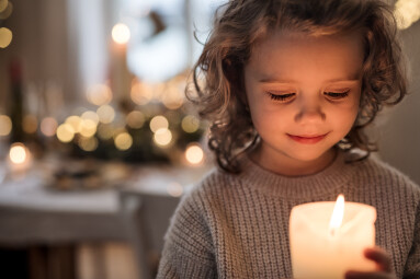 Cheerful,Small,Girl,Indoors,At,Home,At,Christmas,,Holding,Candle.