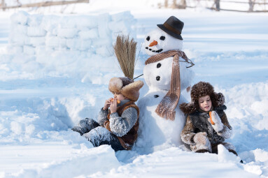 Two,Little,Boys,Sculpt,A,Snowman,In,The,Backyard,Of