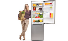 Young,Woman,With,A,Grocery,Bag,Leaning,On,A,Fridge