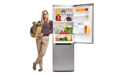 Young,Woman,With,A,Grocery,Bag,Leaning,On,A,Fridge
