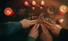 Two,People,Conducting,A,Seance,Using,A,Ouija,Board,,Or