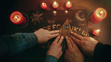 Two,People,Conducting,A,Seance,Using,A,Ouija,Board,,Or