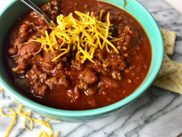 Homemade,Chili,With,Cheese,In,A,Colorful,Bowl,On,White