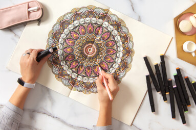 Woman,Drawing,And,Coloring,Mandala,In,Sketchbook,With,Colorful,Markers