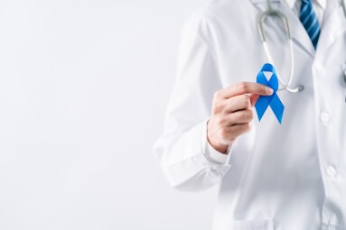 Doctor,In,A,White,Coat,Hands,Holding,Blue,Ribbon,For