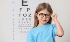 Little,Girl,With,Glasses,Against,Vision,Test,Chart