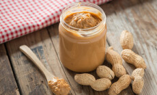 Creamy,And,Smooth,Peanut,Butter,In,Jar,On,Wood,Table.
