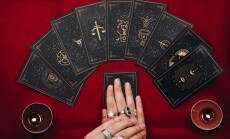 Fortune,Teller,Female,Hands,And,Tarot,Cards,On,A,Red