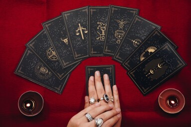 Fortune,Teller,Female,Hands,And,Tarot,Cards,On,A,Red