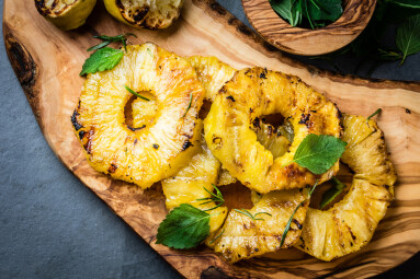 Grilled,Pineapple,Slices,With,Fresh,Mint,On,Olive,Wooden,Cutting