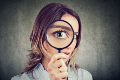 Curious,Young,Woman,Looking,Through,A,Magnifying,Glass