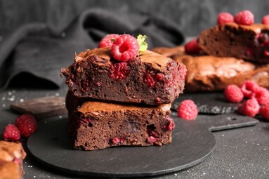 Board,With,Pieces,Of,Raspberry,Chocolate,Brownie,On,Black,Table