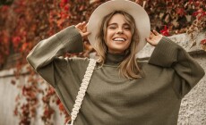 Attractive,Stylish,Woman,Holding,Hat,On,Head,,Walking,In,Park,