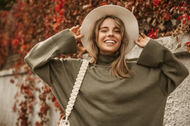 Attractive,Stylish,Woman,Holding,Hat,On,Head,,Walking,In,Park,