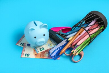 Piggy,Bank,,Money,And,Holder,With,Different,School,Stationery,On