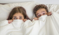 Surprised,Teens,Boy,And,Girl,In,White,Bed