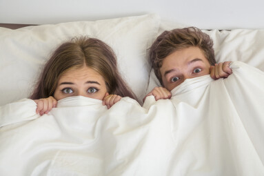 Surprised,Teens,Boy,And,Girl,In,White,Bed