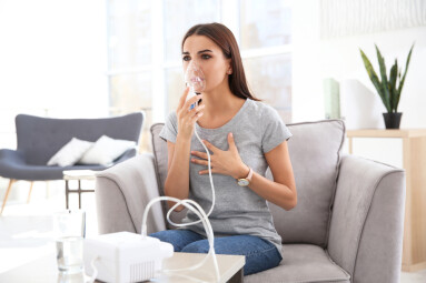 Young,Woman,With,Asthma,Machine,In,Light,Room