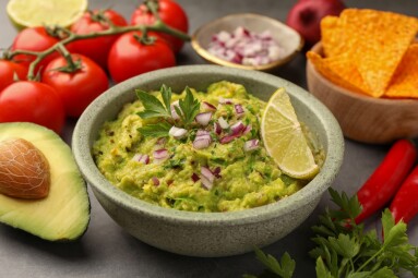 Bowl,Of,Delicious,Guacamole,,Nachos,Chips,And,Ingredients,On,Grey