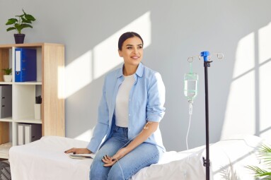 Young,Happy,Smiling,Woman,Sitting,On,The,Couch,In,Medical