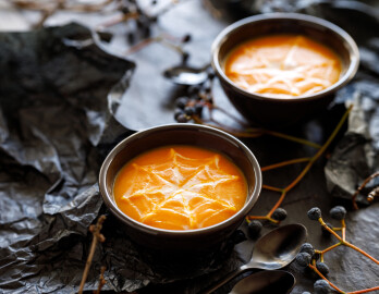 Halloween,Pumpkin,Soup,With,Creamy,Spider,Web,In,Black,Bowls