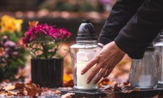 Woman,Is,Putting,Candle,Lantern,At,Grave,In,Cemetery.,Grief