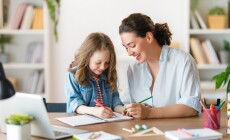 Happy,Child,And,Adult,Are,Sitting,At,Desk.,Girl,Doing