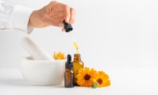 Calendula,Flowers,In,Mortar,,Amber,Glass,Bottles,With,Essential,Oil