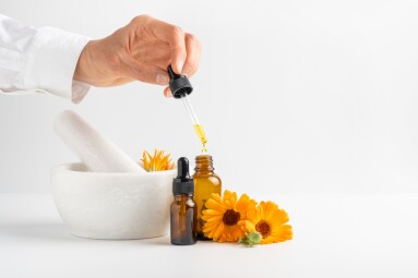 Calendula,Flowers,In,Mortar,,Amber,Glass,Bottles,With,Essential,Oil