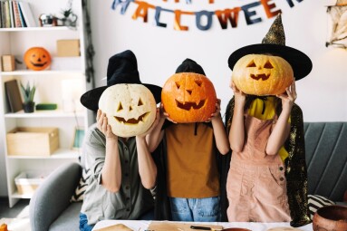 Family,In,Witch,Hats,And,Carved,Pumpkins,,Having,Fun,At