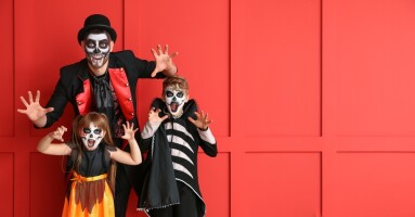 Father,And,Children,In,Halloween,Costumes,On,Red,Background,With